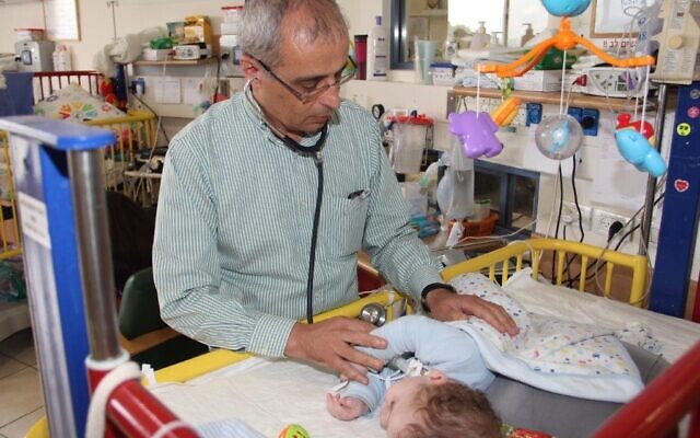 Dr. Eliezer Be'eri of the ALYN Hospital in Jerusalem treating a baby (Courtesy of ALYN Hospital)