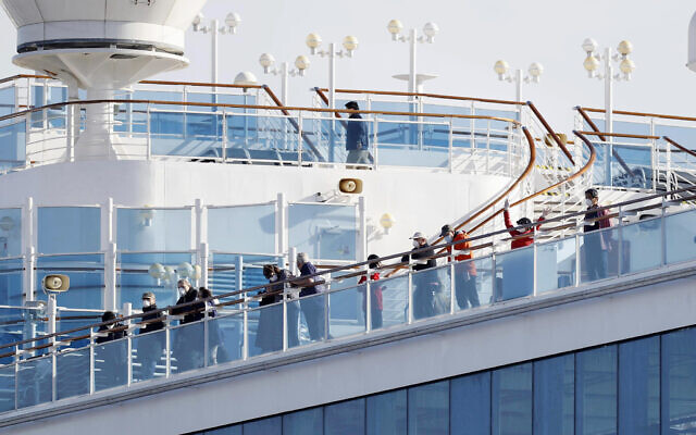 Passengers stand on the deck of the Diamond Princess cruise ship anchored at Yokohama Port in Yokohama, near Tokyo, February 12, 2020. (Yuta Omori/Kyodo News via AP)