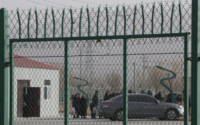 In this December 3, 2018, file photo, residents line up inside the Artux City Vocational Skills Education Training Service Center which has previously been revealed by leaked documents to be a forced indoctrination camp at the Kunshan Industrial Park in Artux in western China's Xinjiang region. (AP/Ng Han Guan, File)