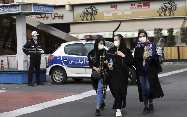 File: A policeman and pedestrians wear masks to help guard against the coronavirus, in downtown Tehran, Iran, February 23, 2020.(Ebrahim Noroozi/AP)