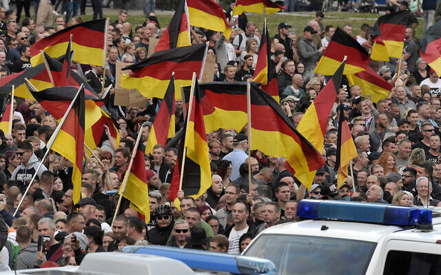 Illustrative: People wave German national flags during a nationalist demonstration in Chemnitz, eastern Germany, September 7, 2018. (Jens Meyer/AP)