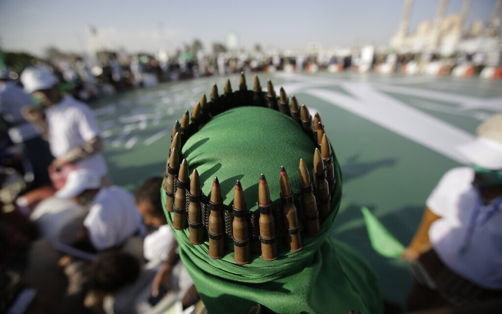 A supporter of the Shiite Houthi rebels with an ammunition belt placed on his head attends a celebration in Sanaa, Yemen, November 9, 2019. (Hani Mohammed/AP)