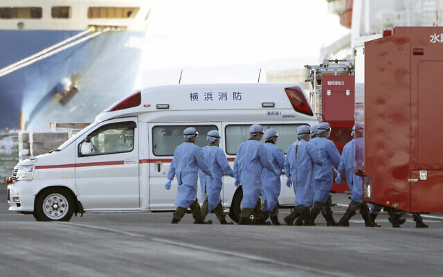 Members of Japan Self Defense Forces walk into the quarantined cruise ship Diamond Princess in the Yokohama Port, Feb. 9, 2020, in Yokohama, Japan (AP Photo/Eugene Hoshiko)