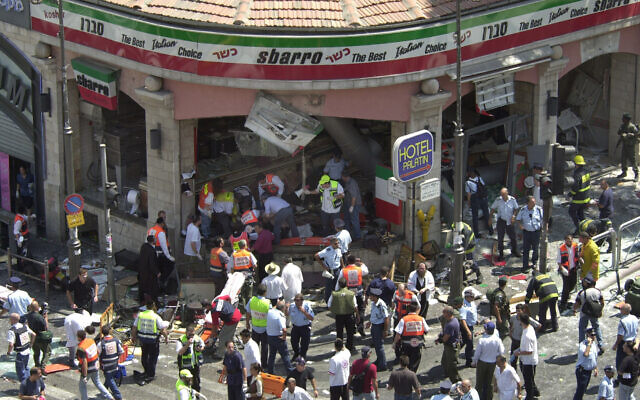 Police and medics surround the scene of a suicide bombing inside Jerusalem's Sbarro restaurant, Thursday, August 9, 2001. Fifteen people were killed, and 130 injured. (AP Photo/Peter Dejong)