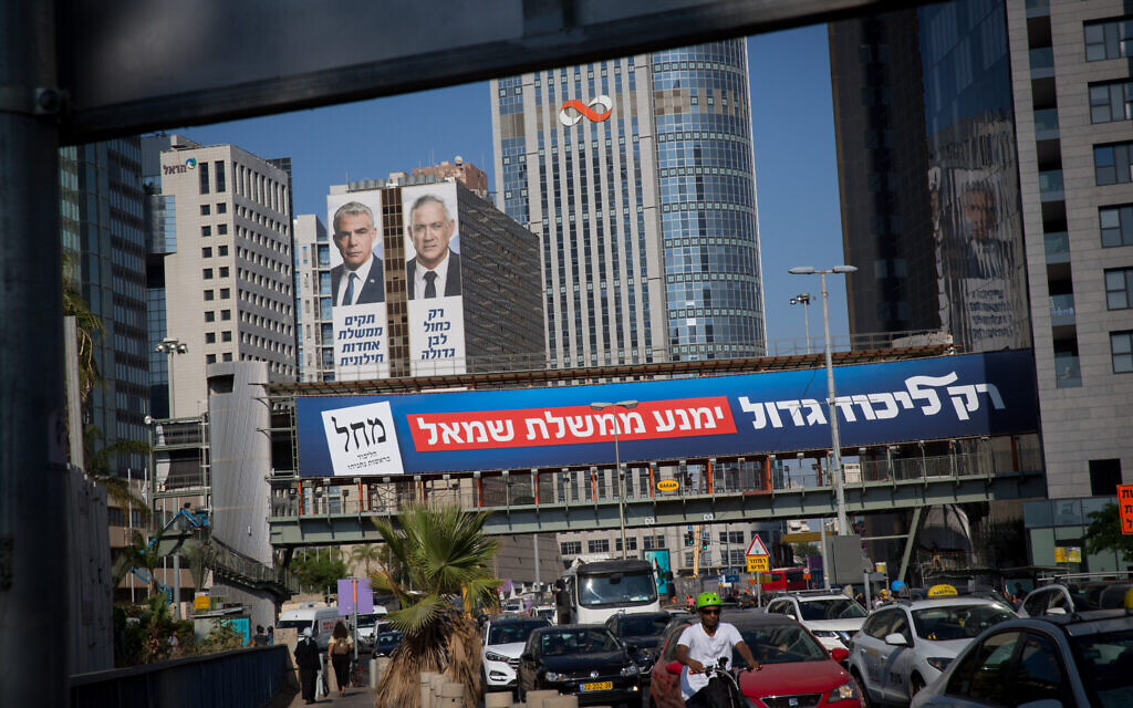 A billboard reading "Only a large Likud will prevent a left-wing government", as part of the Likud election campaign, seen near election posters of Blue and White party heads Yair Lapid and Benny Gantz, in Tel Aviv on September 11, 2019. (Alster/Flash90)
