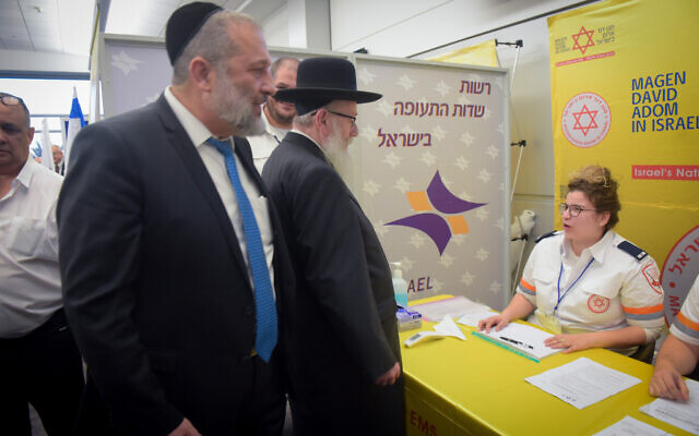 Interior Minister Aryeh Deri, left, and Health Minister Yaakov Litzman visit medical personnel at Ben Gurion International Airport, following reports about the deadly coronavirus, February 2, 2020. (Avshalom Shoshani/ Flash90)