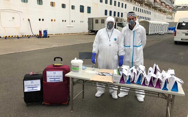 Officials wearing protective clothing wait for Israeli passengers to leave the Diamond Princess cruise ship where they spent two weeks in quarantine due to an outbreak of the coronavirus on board, February 20, 2020. (Israeli Embassy Tokyo)