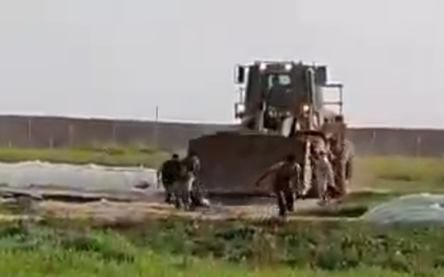 An Israeli military bulldozer enters the Gaza buffer zone to retrieve the body of a suspected terrorist on February 23, 2020. (Screen capture/Shehab news)