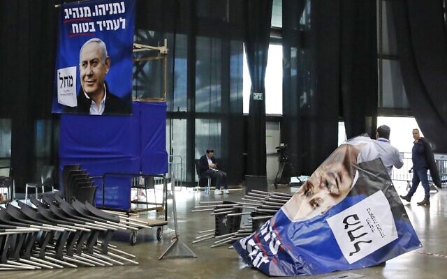 A laborer sorts election posters bearing the portrait of Prime Minister Benjamin Netanyahu, at the Likud party's electoral campaign headquarters in the coastal city of Tel Aviv on March 2, 2020. -(Jack GUEZ / AFP)