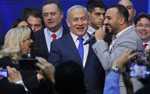 Israeli singer Maor Edri (R) speaks in the microphone as he stands next to Prime Minister Benjamin Netanyahu (C), his wife Sara (L), and Foreign Minister Yisrael Katz (C-L) at the Likud party campaign headquarters in the coastal city of Tel Aviv early on March 3, 2020, after polls officially closed (Jack GUEZ / AFP)