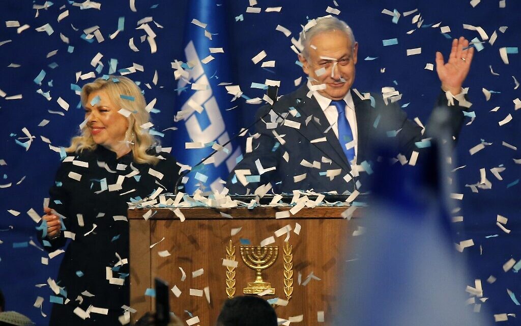 Prime Minister Benjamin Netanyahu and his wife Sara address supporters as confetti falls upon them at the Likud party campaign headquarters in Tel Aviv early on March 3, 2020 (GIL COHEN-MAGEN / AFP)