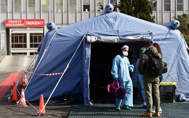 People arrive at a pre-triage medical tent outside Cremona Hospital, in Cremona, northern Italy, on March 4, 2020 (Miguel MEDINA / AFP)