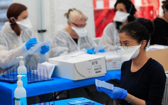 Electoral workers count ballots cast by Israelis under home quarantine after returning from coronavirus infected zones,  in the central town of Shoham on March 4, 2020. (Emmanuel Dunand/AFP)