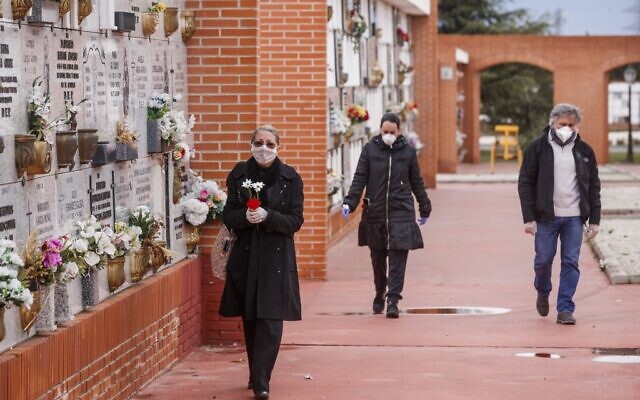 People wearing face masks arrive at the South Municipal cemetery in Madrid, to attend the burial of a man who died of the new coronavirus, on March 23, 2020. (BALDESCA SAMPER/AFP)