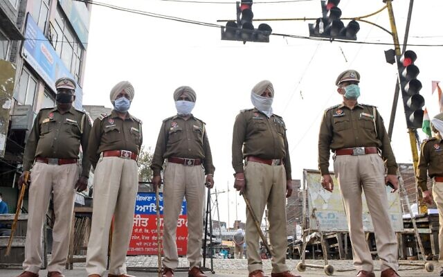 Police personnel in India stand guard at a traffic light during the first day of a 21-day government-imposed nationwide lockdown as a preventive measure against the COVID-19 coronavirus, in Amritsar on March 25, 2020. (Narinder Nanu/AFP)