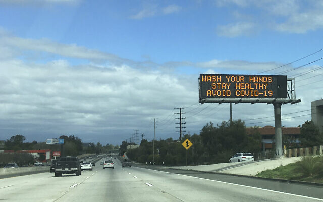 A Caltrans freeway sign reads: "Wash your hands, Stay healthy, Avoid COVID-19" in the San Fernando Valley section of Los Angeles. (AP Photo/John Antczak)