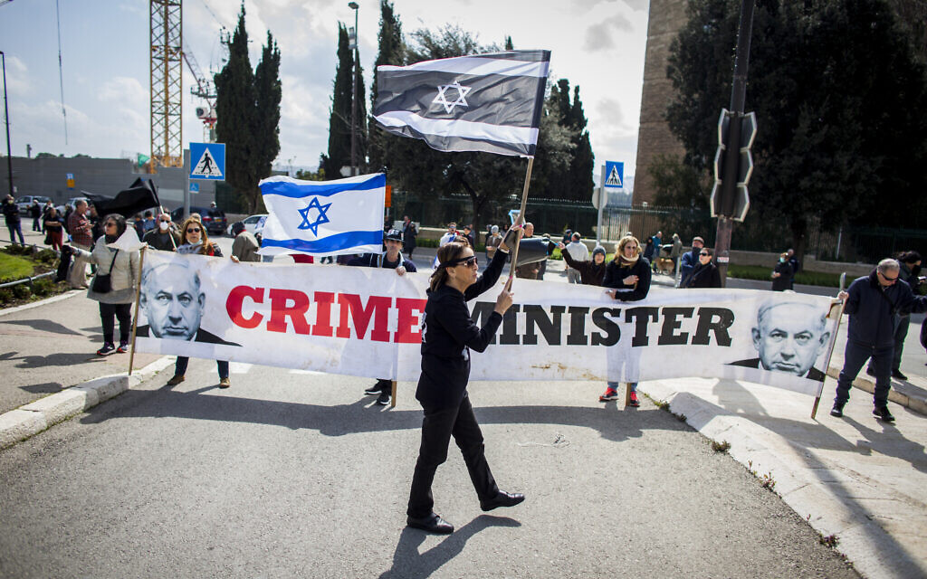 People wave Israeli flags, inverted Israeli flags and banners during a protest outside the Israeli parliament in Jerusalem, Thursday, March 19, 2020, accusing Prime Minister Benjamin Netanyahu's government of exploiting the coronavirus crisis to cement his power and undermine Israel's democratic foundations. (AP Photo/Eyal Warshavsky)