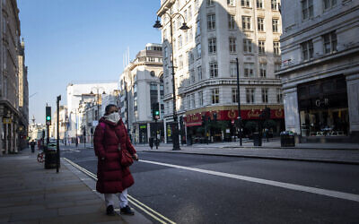 A woman walks down the Strand during "rush hour" in Westminster, London, March 26, 2020. (Victoria Jones/PA via AP)