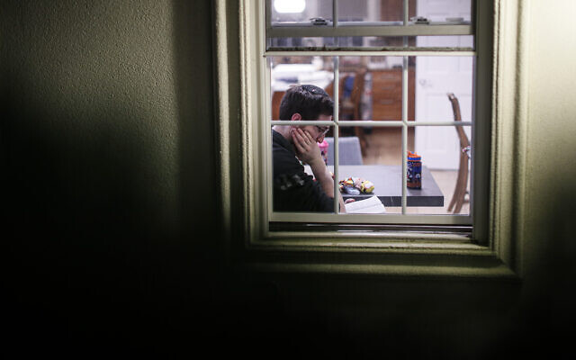 A self-quarantined resident who claims to have tested positive for COVID-19 listens beside his window as volunteers perform a Purim reading from the Book of Esther, Monday, March 9, 2020, in New Rochelle, N.Y. (AP/John Minchillo)