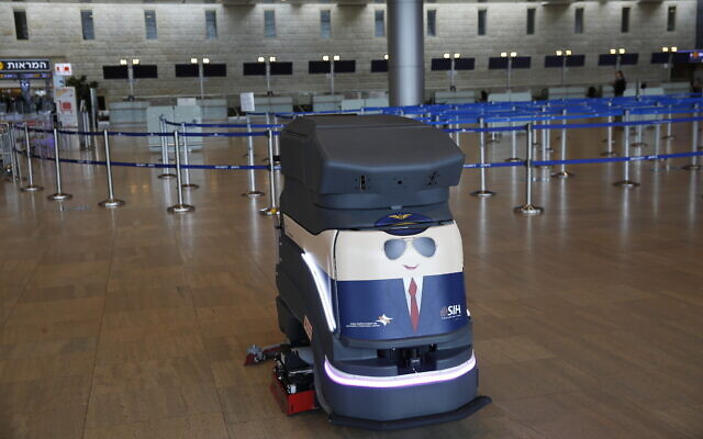 A robot cleans the hall of empty check-in counters at the Ben Gurion Airport near Tel Aviv, Israel, Tuesday, March 10, 2020.  (AP/Ariel Schalit)
