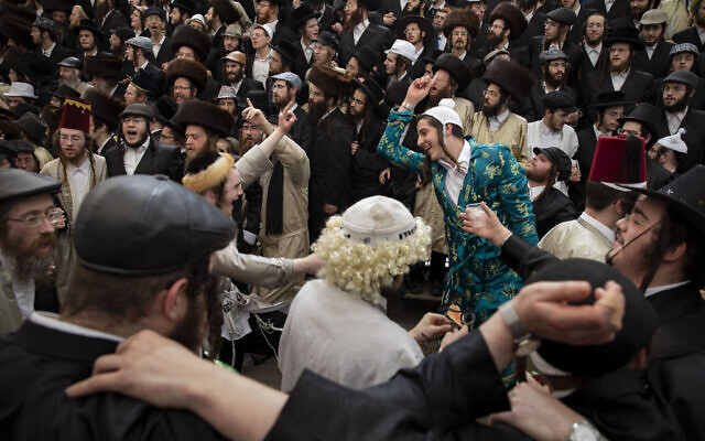 Illustrative: Ultra-Orthodox Jewish men celebrate the Jewish holiday of Purim in Jerusalem’s Mea Shearim neighborhood on March 11, 2020. (AP Photo/Oded Balilty)