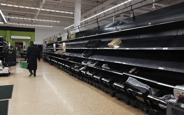 Shelves are empty in the fruit and vegetable section of an Asda store in London on March 14, 2020. (Yui Mok/PA via AP)