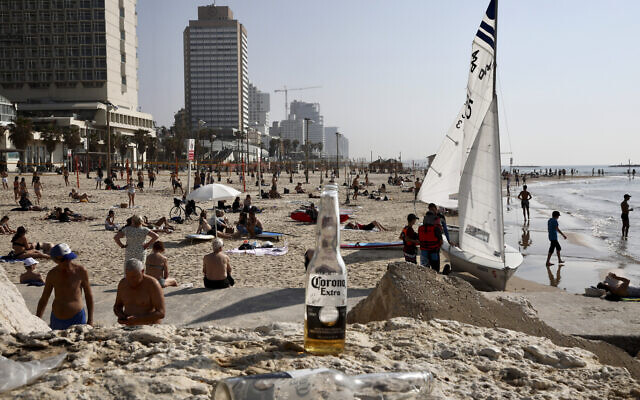 Israelis enjoy the beach in Tel Aviv, March 16, 2020. (AP Photo/Oded Balilty)