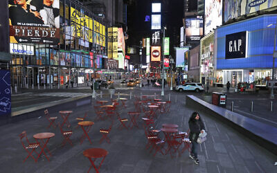 A woman walks through a lightly trafficked Times Square in New York, March 16, 2020. (AP/Seth Wenig)
