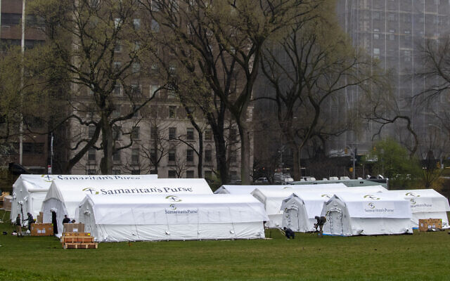 A Samaritan’s Purse crew works on building a 68-bed emergency field hospital, specially equipped with a respiratory unit, in New York’s Central Park across from The Mount Sinai Hospital, March 29, 2020. (AP Photo/Mary Altaffer)