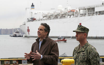 New York Governor Andrew Cuomo, left, speaks as he stands beside Rear Adm. John B. Mustin after the arrival of the USNS Comfort, a naval hospital ship with a 1,000 bed-capacity, March 30, 2020, at Pier 90 in New York. (AP Photo/Kathy Willens)