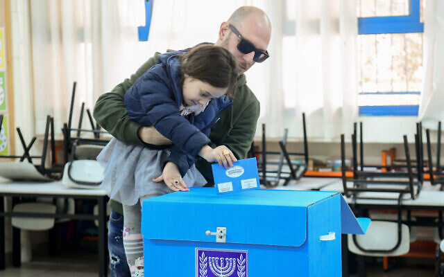 A voter and his daughter cast a ballot at a voting station in Tel Aviv, March 2, 2020 (Flash90)