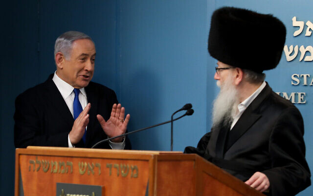 Prime Minister Benjamin Netanyahu (left) with then-health minister Yaakov Litzman, in Jerusalem, on March 11, 2020. (Flash90)