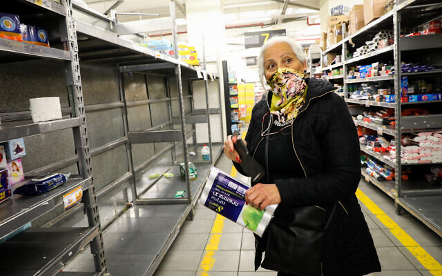 An Israeli woman shops at a supermarket in Jerusalem on March 14, 2020 (Yossi Zamir/Flash90)