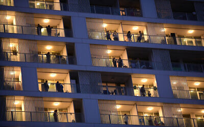 Israelis on their balconies in Tel Aviv on March 19, 2020. (Tomer Neuberg/Flash90)