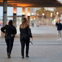 Police patrol on the Tel Aviv beach boardwalk on March 25, 2020. (Avshalom Sassoni/Flash90)