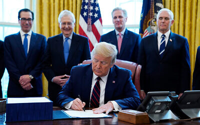 US President Donald Trump signs the coronavirus stimulus relief package at the White House in Washington, DC, March 27, 2020. From left: Treasury Secretary Steven Mnuchin, Senate Majority Leader Mitch McConnell of Kentucky, House Minority Kevin McCarthy of California, and Vice President Mike Pence. (AP/Evan Vucci)