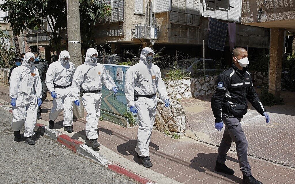 Koruyucu kıyafetler giymiş İsrailli polis memurları, yeni yetkililer tarafından uygulanan coronavirüsün yayılmasını engellemek amacıyla 2 Nisan 2020'de İsrail şehri Bnei Brak'ta bir yeshiva'ya varıyorlar.  (JACK GUEZ / AFP)