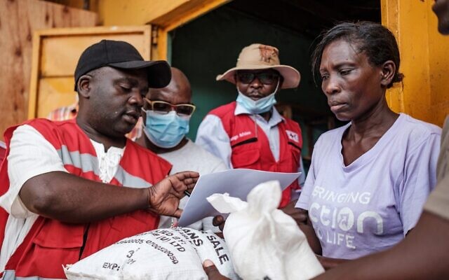 Red Cross volunteers register people during the first day of the government's food distribution for people who have been affected by the lockdown in Kampala, Uganda, on April 4, 2020. (SUMY SADURNI/AFP)