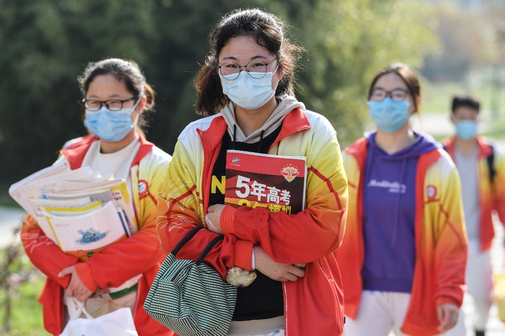 High school grade three students wearing face masks arrive at school after the term opening was delayed due to the COVID-19 coronavirus outbreak, in Bozhou in China's eastern Anhui province on April 7, 2020.(Photo by STR / AFP)