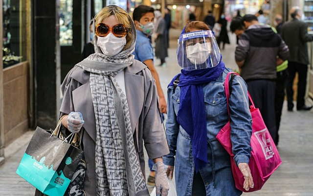 Shoppers clad in protective gear, including face masks and shields and latex gloves, due to the COVID-19 pandemic, walk through the Tajrish Bazaar in Iran's capital Tehran on April 25, 2020, during the Muslim holy month of Ramadan. (ATTA KENARE / AFP)