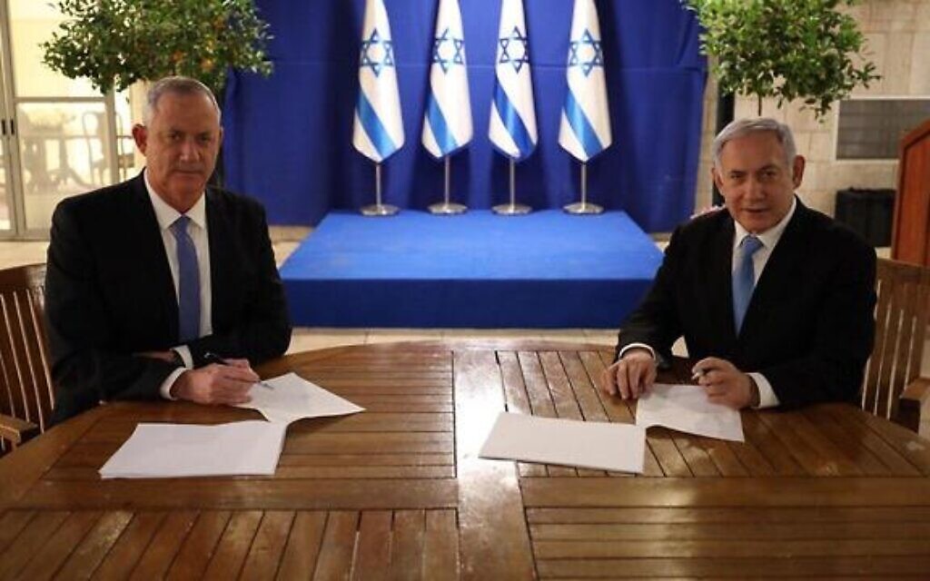 Blue and White leader Benny Gantz (left) and Prime Minister Benjamin Netanyahu sign their unity government agreement on April 20, 2020. (GPO)