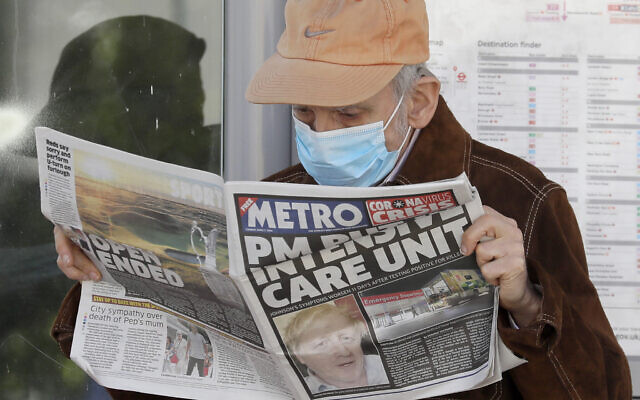 A man reads a newspaper with the headline: ‘PM in intensive care’, outside St Thomas’ Hospital in central London as British Prime Minister Boris Johnson is in intensive care fighting the coronavirus in London on April 7, 2020. (AP Photo/Kirsty Wigglesworth)