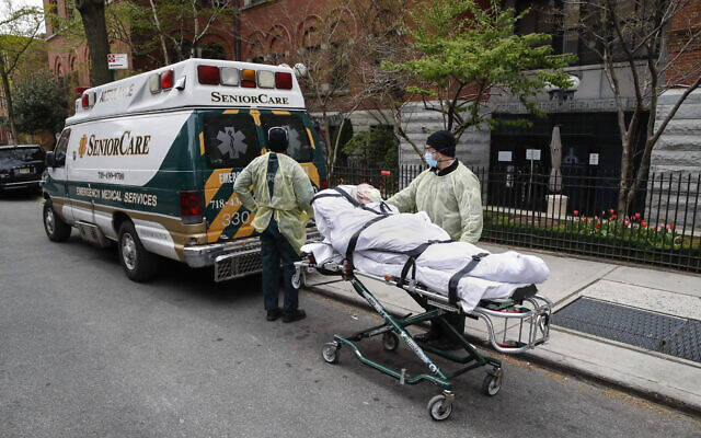 A patient is wheeled out of Cobble Hill Health Center by emergency medical workers, in Brooklyn, NY, April 17, 2020. (AP Photo/John Minchillo)
