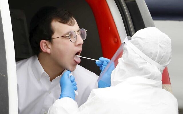 An ultra-Orthodox youth is tested for the coronavirus in Bnei Brak, March 31, 2020. (Ariel Schalit/ AP)