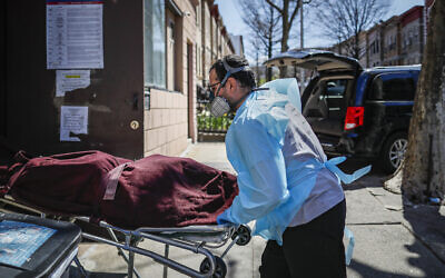 Employees deliver a body at Daniel J. Schaefer Funeral Home, Thursday, April 2, 2020, in the Brooklyn borough of New York. (AP/John Minchillo)