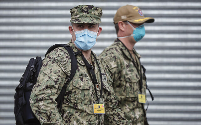 US Navy personnel wearing surgical masks to protect against the coronavirus, arrive at Wyckoff Heights Medical Center on April 7, 2020, in the Brooklyn borough of New York. (AP/John Minchillo)
