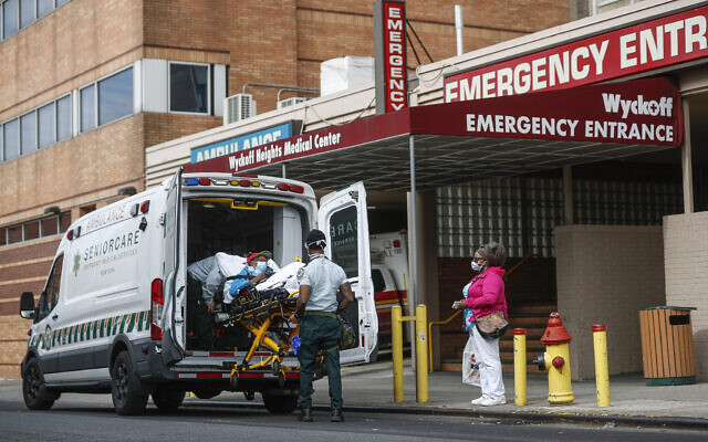 Patients are brought into Wyckoff Heights Medical Center by staff wearing personal protective gear due to COVID-19 concerns, Tuesday, April 7, 2020, in the Brooklyn borough of New York (AP Photo/John Minchillo)