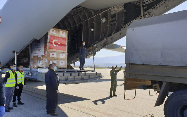 In this handout photo provided by the Turkish Defense Ministry, North Macedonian officials unload Personal Protection Equipment donated by Turkey to help the country combat the  coronavirus outbreak,  April 8, 2020.  (Turkish Defence Ministry via AP)
