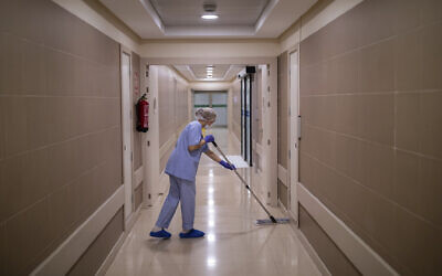 In this April 16, 2020 photo, a staffer disinfects an alley of the Clinica CEMTRO in Madrid, Spain. (AP Photo/Bernat Armangue)