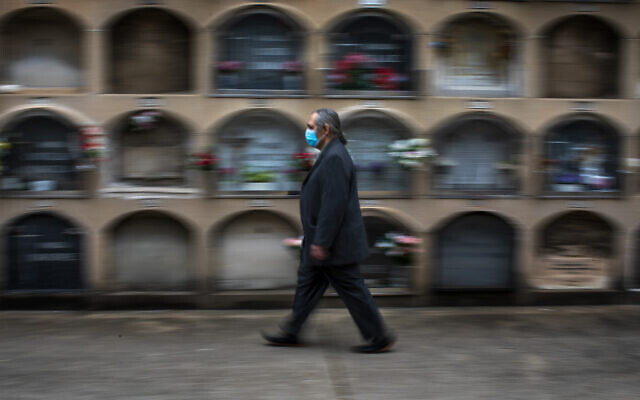 A man arrives at the the Poble Nou cemetery in Barcelona, Spain, April 18, 2020, to attend the funeral of his mother who died of coronavirus. (AP Photo/Emilio Morenatti)